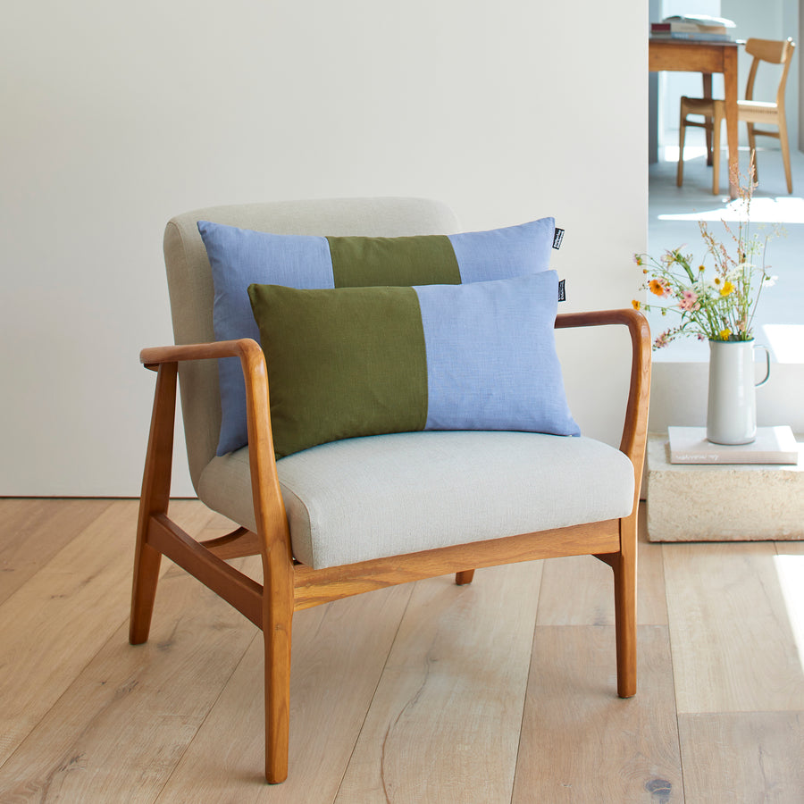 CATHERINE COLEBROOK DOUBLE COLOUR BLOCK DENIM JUNGLE CUSHION ON A CHAIR