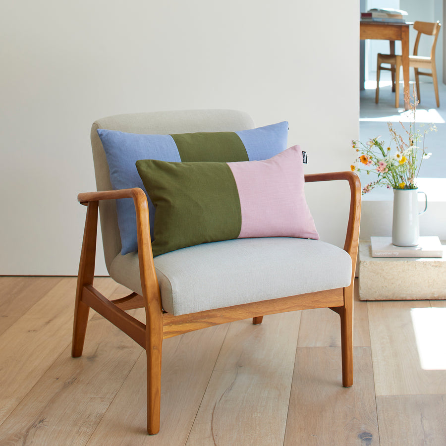 CATHERINE COLEBROOK DOUBLE COLOUR BLOCK DUSKY JUNGLE CUSHION ON A CHAIR WITH THE DENIM JUNGLE TRIPLE COLOUR BLOCK CUSHION