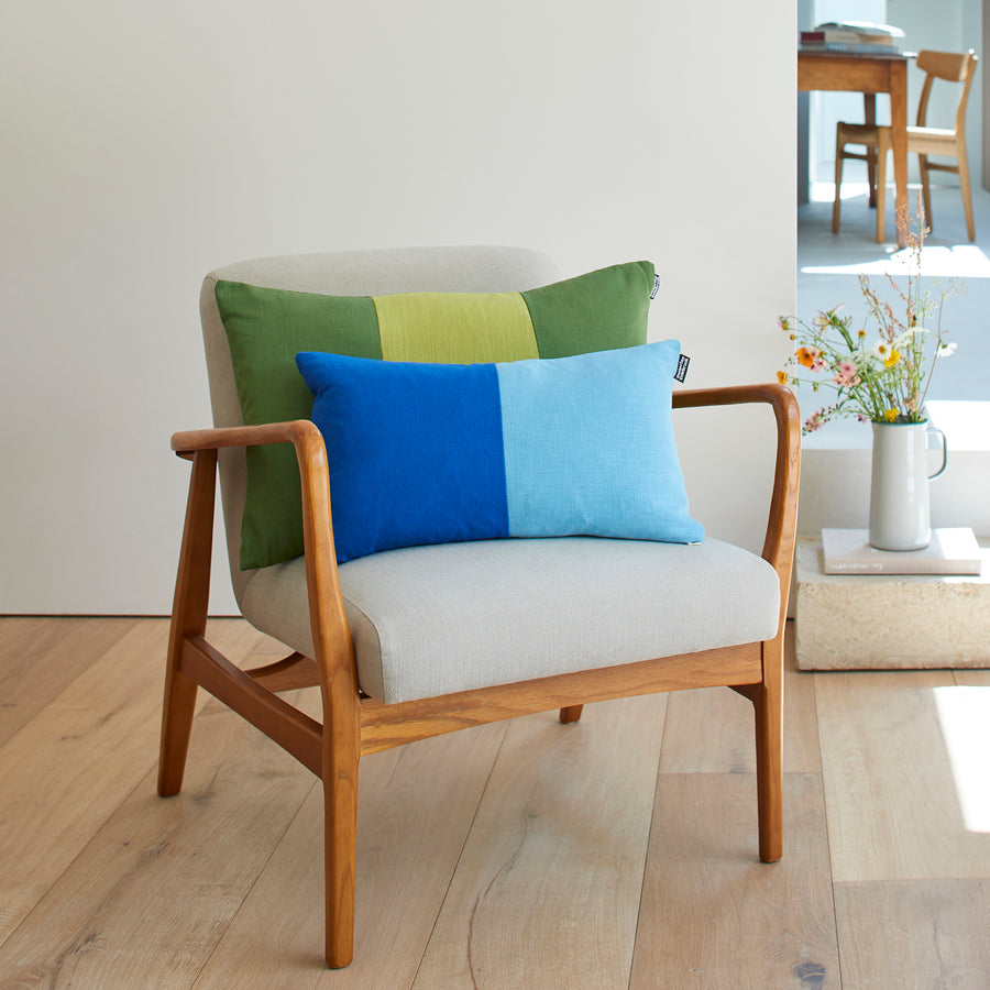 CATHERINE COLEBROOK DOUBLE COLOUR BLOCK ROYAL AZURE CUSHION ON A CHAIR WITH THE OLIVE CHARTREUSE TRIPLE COLOUR BLOCK CUSHION