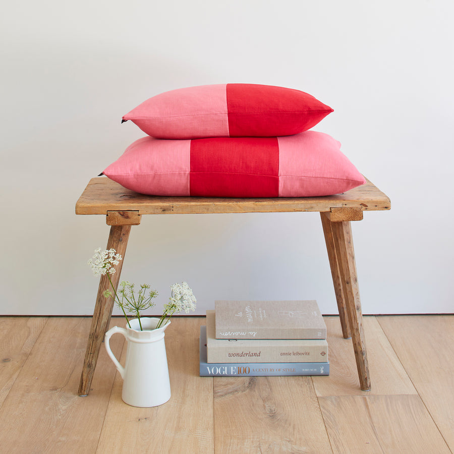 CATHERINE COLEBROOK DOUBLE COLOUR BLOCK CHERRY ROSE CUSHION ON A BENCH