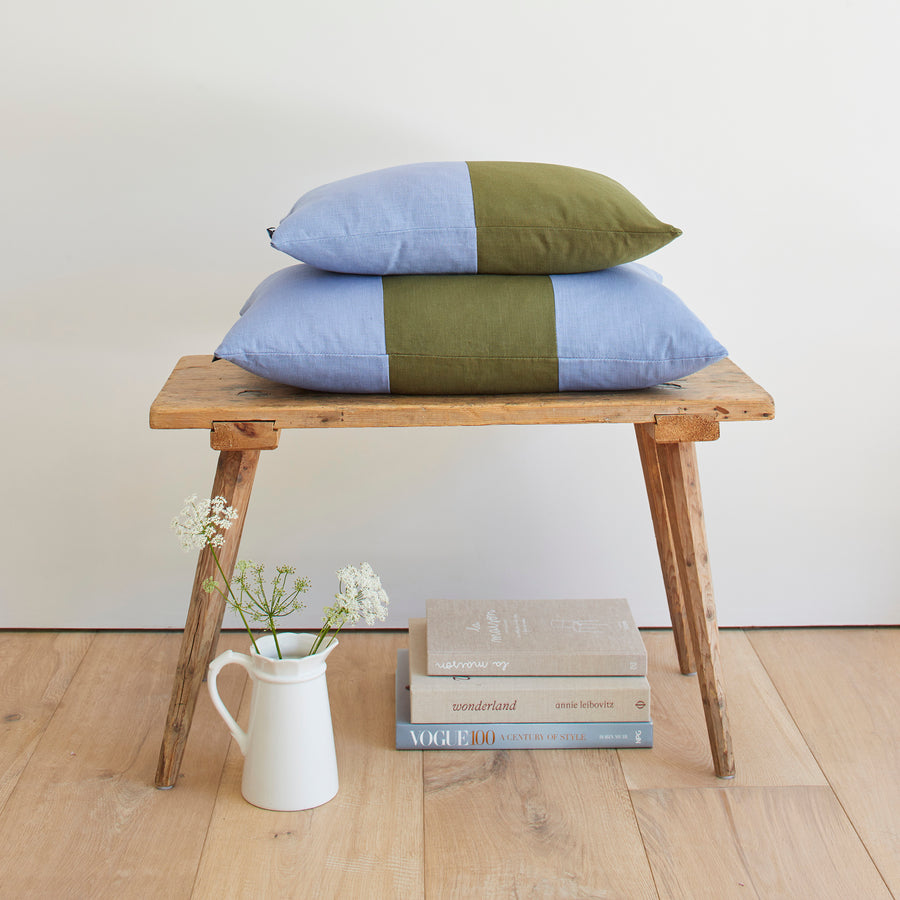 CATHERINE COLEBROOK DOUBLE COLOUR BLOCK DENIM JUNGLE CUSHION ON A BENCH