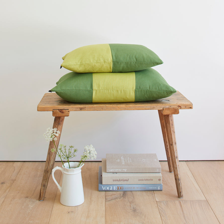 CATHERINE COLEBROOK DOUBLE COLOUR BLOCK OLIVE CHARTREUSE CUSHION ON A BENCH