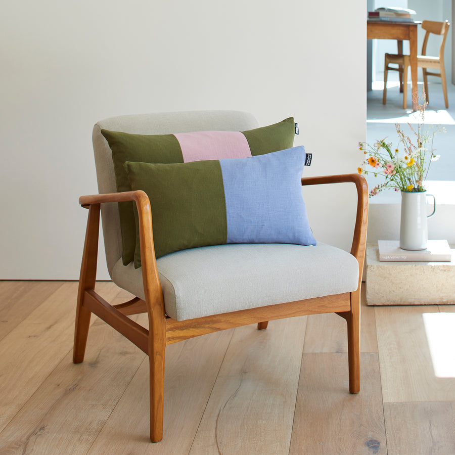 CATHERINE COLEBROOK DOUBLE COLOUR BLOCK DENIM JUNGLE CUSHION ON A CHAIR WITH THE DUSKY JUNGLE TRIPLE COLOUR BLOCK CUSHION