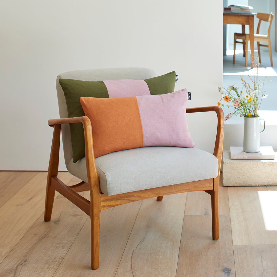 CATHERINE COLEBROOK DOUBLE COLOUR BLOCK DENIM JUNGLE CUSHION ON A CHAIR WITH THE DUSKY JUNGLE TRIPLE COLOUR BLOCK CUSHION